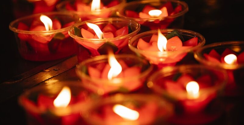 Multiple flower candles burn spiritual fire